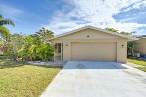 una casa con garaje en un patio en 3 Mi to Naples Botanical Garden Home with Hot Tub!, en Naples