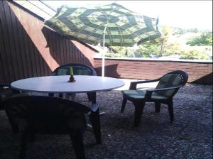 ein Tisch und Stühle und ein Sonnenschirm auf einer Terrasse in der Unterkunft Studio für 4 Personen ca 90 qm in Bad Lauterberg im Harz, Harz Harz Niedersachsen in Bad Lauterberg