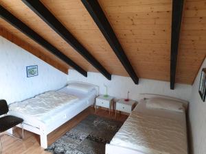 two beds in a room with wooden ceilings at Paradies Hoffmann in Bad Lauterberg