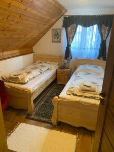 two twin beds in a room with a window at PRIVAT MARIANNA in Žakovce