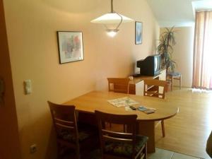 une salle à manger avec une table en bois et une télévision dans l'établissement Wohnung In Bad Kötzting, à Bad Kötzting