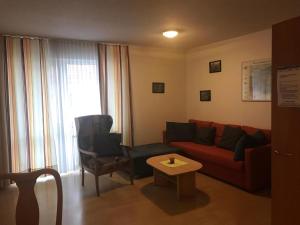 - un salon avec un canapé rouge et une chaise dans l'établissement Wohnung In Bad Kötzting, à Bad Kötzting