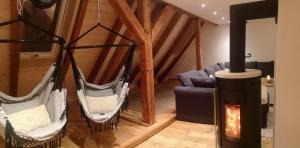 un salon avec deux hamacs suspendus et une cheminée dans l'établissement Moderne Ferienwohnung Mit Hot Tub Und Fasssauna, à Hohenberg an der Eger