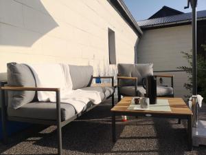 - une terrasse avec 2 canapés et une table basse dans l'établissement Moderne Ferienwohnung Mit Hot Tub Und Fasssauna, à Hohenberg an der Eger