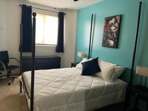 a bedroom with a bed with blue walls at Casa Perrine at Linda Vista 2-412 in Las Conchas