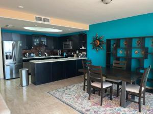 a kitchen with a wooden table and a blue wall at Casa Perrine at Linda Vista 2-412 in Las Conchas