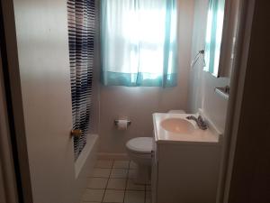 a bathroom with a toilet and a sink and a window at Blue Haven Apartments in Ocean City