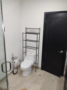 a bathroom with a toilet and a black door at Casa Perrine at Linda Vista 2-412 in Las Conchas +9 photos