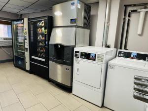 a kitchen with a refrigerator and two refrigerators at Quality Inn Raynham - Taunton in Raynham