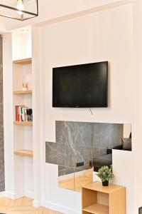 ein Wohnzimmer mit einem TV über einem Kamin in der Unterkunft Studio Raffiné près de la Seine Paris 16ème in Paris