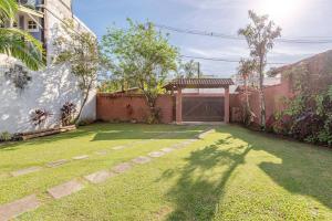 un cortile con cancello e un prato di Casa com piscina a 100 m de Camburizinho a Camburi