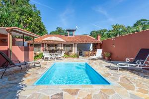 una villa con piscina e una casa di Casa com piscina a 100 m de Camburizinho a Camburi