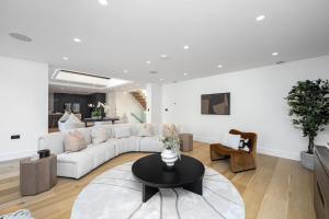 a living room with a white couch and a table at Luxe Retreat 5-Bedroom Designer Home Pool & Cinema in Brighton & Hove +29 photos