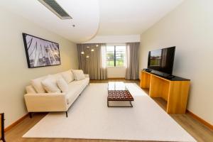 a living room with a couch and a tv at Golden Tulip Brasília Alvorada in Brasilia