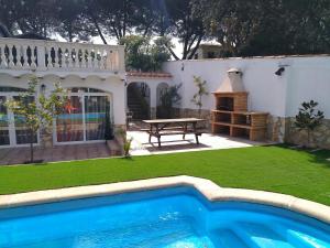 a backyard with a swimming pool and a picnic table at Allotjament Bogues in Lloret de Mar