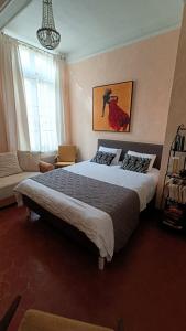 a bedroom with a large bed and a couch at La Chouette Maison in Florensac
