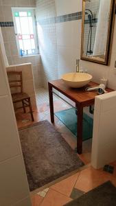 a bathroom with a sink and a table with a mirror at La Chouette Maison in Florensac