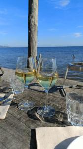 two glasses of white wine sitting on a table near the ocean at La Chouette Maison in Florensac +21 photos