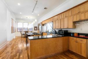 una cocina con armarios de madera y encimeras negras en Spacious 3BR Downtown Condo in New Orleans, en Nueva Orleans