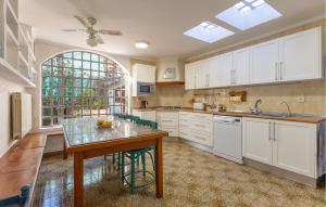 a kitchen with white cabinets and a table and a window at Stunning Home In El Campello in El Campello