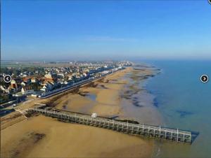 an aerial view of a beach with a pier at La Lutine in Luc-sur-Mer +5 photos