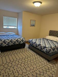 a bedroom with two beds and a chair in it at Cozy 3-Bed Retreat in Fairbanks in Fairbanks