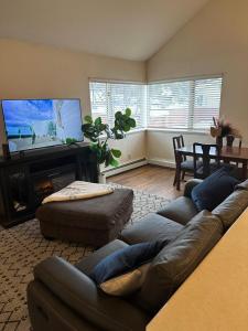 a living room with a couch and a flat screen tv at Cozy 3-Bed Retreat in Fairbanks in Fairbanks