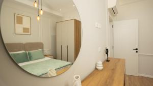a mirror reflecting a bedroom with a bed in a room at ProGarden Luxury Apartments Tirana in Tirana +214 photos