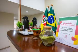 a table with a jar of green sauce and flags at Hotel Express Confort in São Leopoldo