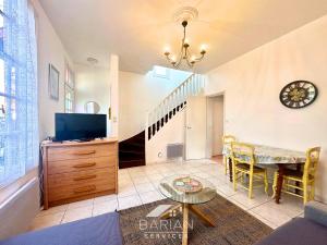 a living room with a tv and a staircase at Bord de mer 60 m - Charmante Maison 5 personnes in Fouras