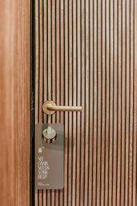 a door with a sign on a wooden wall at Selvario 36 Hotel in Medellín