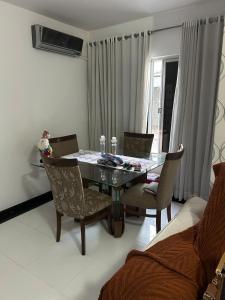 a dining room with a glass table and chairs at Apartamento Kobrasol - Ótima localização in São José