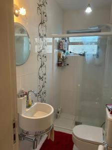 a bathroom with a sink and a toilet and a shower at Apartamento Kobrasol - Ótima localização in São José
