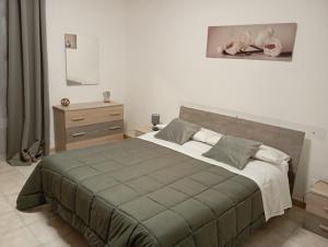 a bedroom with a large bed and a dresser at Vittoria House in Sciacca