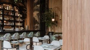 a dining room with tables and chairs and a bar at Selvario 36 Hotel in Medellín