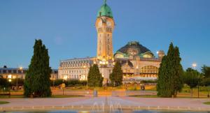 a large building with a clock tower in front of it at Le Gari, Limoges in Limoges