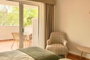 a bedroom with a bed and a chair and a patio at Pátio das Ribeiras in Almeirim +98 photos