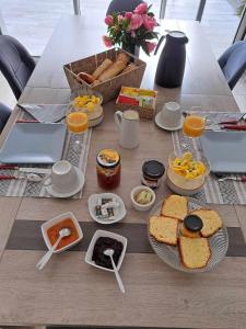 a table with breakfast foods and fruit on it at Les reflets du golfe in Arradon