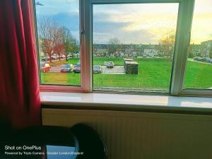 a window with a view of a parking lot at London's B& B in Hornchurch