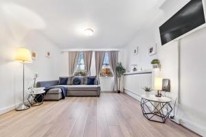 a living room with a couch and a table at The Queensborough Apartments by Hyde Park in London
