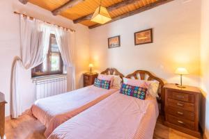 a bedroom with two beds and a window at Casa Rural El Cencerro in Villamanrique de Tajo +29 photos