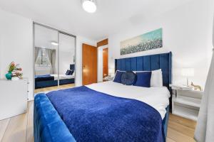 a blue and white bedroom with a large bed at The Queensborough Apartments by Hyde Park in London