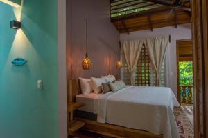 a bedroom with a white bed in a room at P2 Tucan in Talamanca