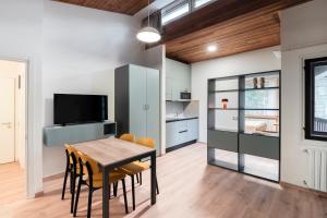 a kitchen and dining room with a table and chairs at Appartamenti Corte Residence in Borca di Cadore