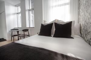 a white bed with black pillows in a bedroom at Studio #9 - Self Check-In - Plateau - St-Denis in Montreal