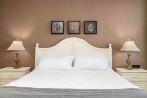 a bedroom with a white bed with two lamps at Panoramic Penthouse at SDC in Branson +37 photos