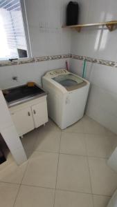 a small bathroom with a toilet and a sink at Half Beach Apartment - Itapema in Itapema +6 photos