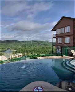 a swimming pool with a house and a building at Panoramic Penthouse at SDC in Branson