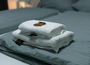 a pile of towels sitting on top of a bed at Modern Apartments Neuburg S - NEU - 2 Zimmer, Parkplatz, Wi-Fi, TV, Küche in Neuburg an der Donau