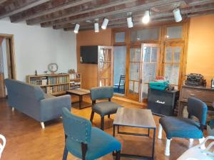 a living room with chairs and a table and a tv at Arpegio Hostel in San Rafael